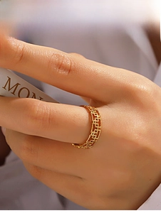Détail d'une bague géométrique évidée plaquée or 18 carats au doigt pour femmes