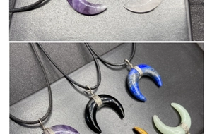Detail view of crescent moon natural stone pendants with wire wrapping on black cords