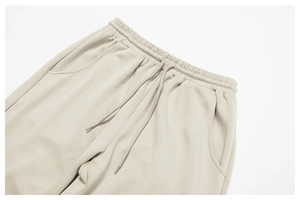 Detail des hohen elastischen Bunds mit Kordelzug an beiger weiter Jogginghose