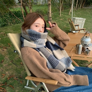 Outdoor camping shot showing blue and grey plaid scarf with fringe on a model