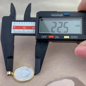 Detailed view showing the 22.5 mm height measurement of the gold oval shell pendant