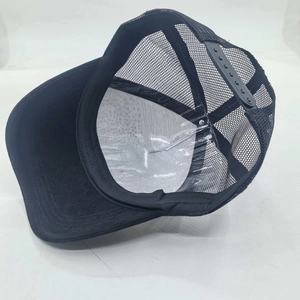 Detail view of the black trucker hat featuring breathable mesh and adjustable snap closure