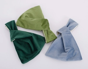 Three velvet wristlet bags in dark green, light green, and blue on a clean white background