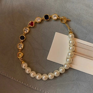 Détail du bracelet plaqué or 18 carats avec pierres en zircon colorées et perles blanches