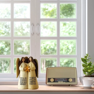 Detail of resin angel sculpture with friendship quote on vintage radio background