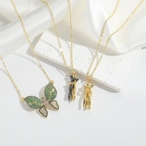 Elegant gold butterfly pendant and lover motif necklaces on luxurious white silk backdrop