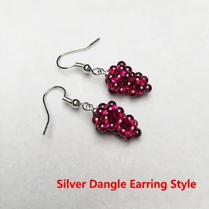 Detail view of handmade silver drop earrings with burgundy grape-shaped bead clusters