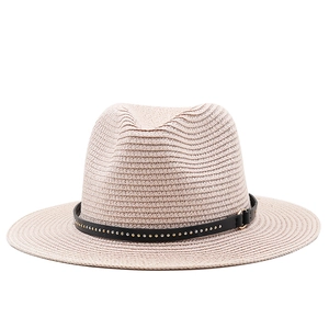 Detail of light beige straw fedora featuring a black leather band with silver metal studs