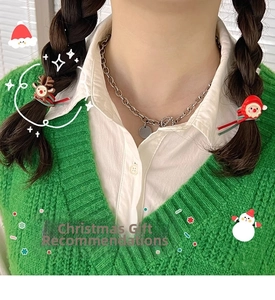 Close-up of festive Christmas hair ties featuring Santa and reindeer on a green sweater