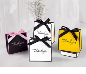 Minimalist paper gift bags with Thank You print and elegant bow ribbon decorations