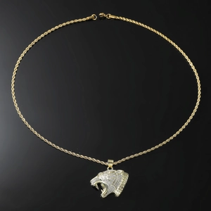 Macro shot of gold hip-hop leopard head pendant with sparkling crystals on rope chain