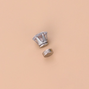 Macro detail of magnetic earring with six-claw zircon stone and silver steel base