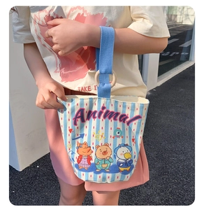 Detail of canvas bucket bag with cartoon animal prints and blue striped pattern design