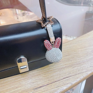 Sparkling crystal rabbit head keychain with silver and red rhinestones on a black leather bag