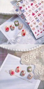 Macro detail of cherry and bow nail art stickers on nails with sweet vibrant patterns