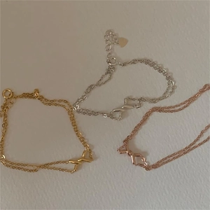 Detailed view of 925 silver double-layer bracelets with X-shaped cross charms in three tones
