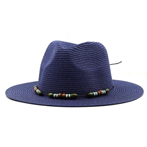 Detail of navy blue straw Panama hat featuring a colorful ethnic beaded band and flat brim
