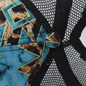 Detail of printed blue fabric and breathable black mesh on a ponytail baseball cap