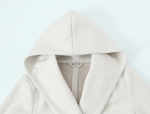 Detail of oatmeal hooded coat collar showing premium wool texture and stitching