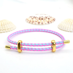 Detailed view of pink and light blue braided bracelet with adjustable gold metal slider