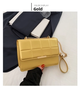 Detail of gold quilted chain bag with elegant metallic square texture and golden clasp