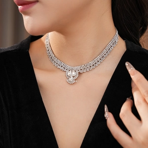 Macro view of multi-layered silver rhinestone necklace with teardrop pendant on model