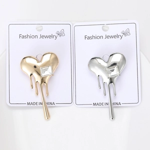 Detailed macro view of melting heart brooches with rhinestones on fashion jewelry card