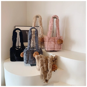 Close-up of five colorful plush woven shoulder bags with cute bear pendants on display