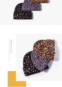 Dettaglio di berretti in maglia invernali con motivi leopardati marroni, viola e grigi