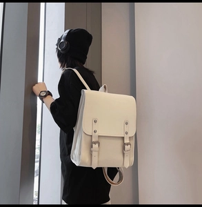 Model wearing a minimalist cream white faux leather backpack in Japanese college style