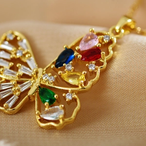 Vue macro du pendentif papillon doré avec des pierres précieuses colorées incrustées