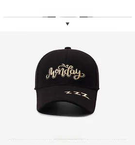 Detail of golden 'Monday' and 'ZZZ' embroidery on a black cotton baseball cap