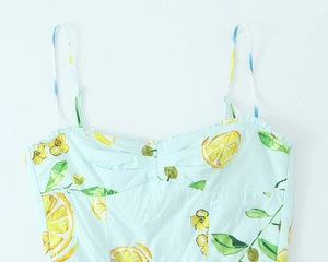 Detail of light blue poplin dress with lemon print featuring ruffled bodice and thin straps