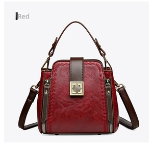 Detailed view of the red bucket bag showing stitching and vintage gold buckle hardware