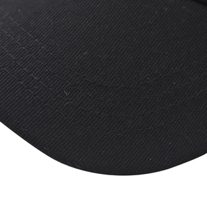 Macro shot of cotton twill texture and neat stitching on a black baseball cap brim