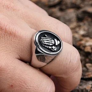 Vintage stainless steel signet ring with embossed praying hands and oxidized finish