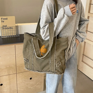 Vintage army green oversized canvas tote bag with distressed fringe and floral patch detail