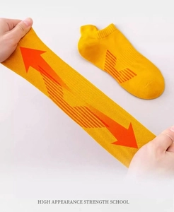 Close-up showing the high horizontal elasticity of the yellow cotton athletic ankle socks
