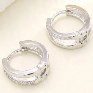 Macro shot of silver hollow H-shaped earrings with micro-pave white cubic zirconia