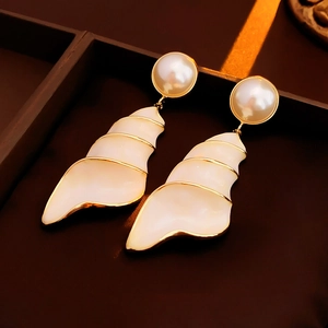 Macro detail of vintage seashell earrings with pearl stud and golden metal trim edges