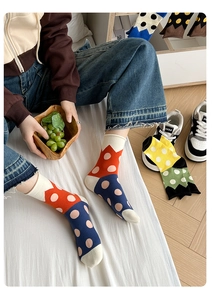 Detailed close-up of colorful polka dot knit socks in red, blue, and yellow patterns