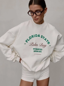 White crewneck sweatshirt featuring green Florida State lettering and a loose fit cut