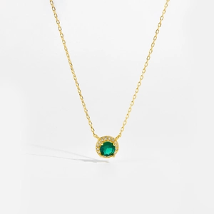 Detailed close-up of S925 silver necklace with emerald zircon pendant in gold plating