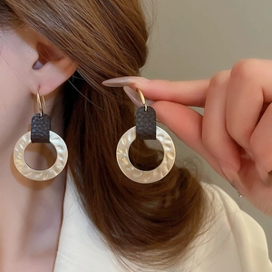 Matte gold leaf earrings with textured metal and brown leather inserts for women