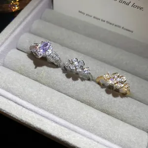 Elegant zircon flower open rings with clover designs and purple gemstone in a velvet box