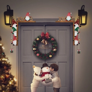 Christmas door frame decoration with gnomes and XMAS letters on a grey door corner