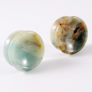 Macro shot of double flared natural stone ear gauges with unique organic textures