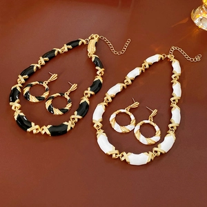 Detail of vintage twisted geometric enamel necklace and earring sets in gold, black and white