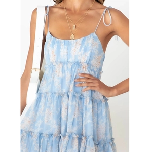 Detailed close-up of light blue floral print sundress with ruffle hem and strap details