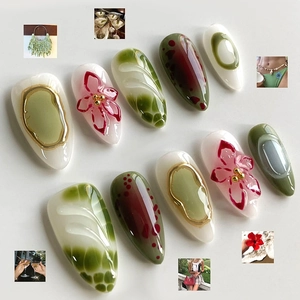 Short almond press-on nails with green marble design and 3D red floral art accents